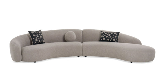Glam Curved Sectional Sofa upholstered in taupe fabric with black and taupe accent pillows